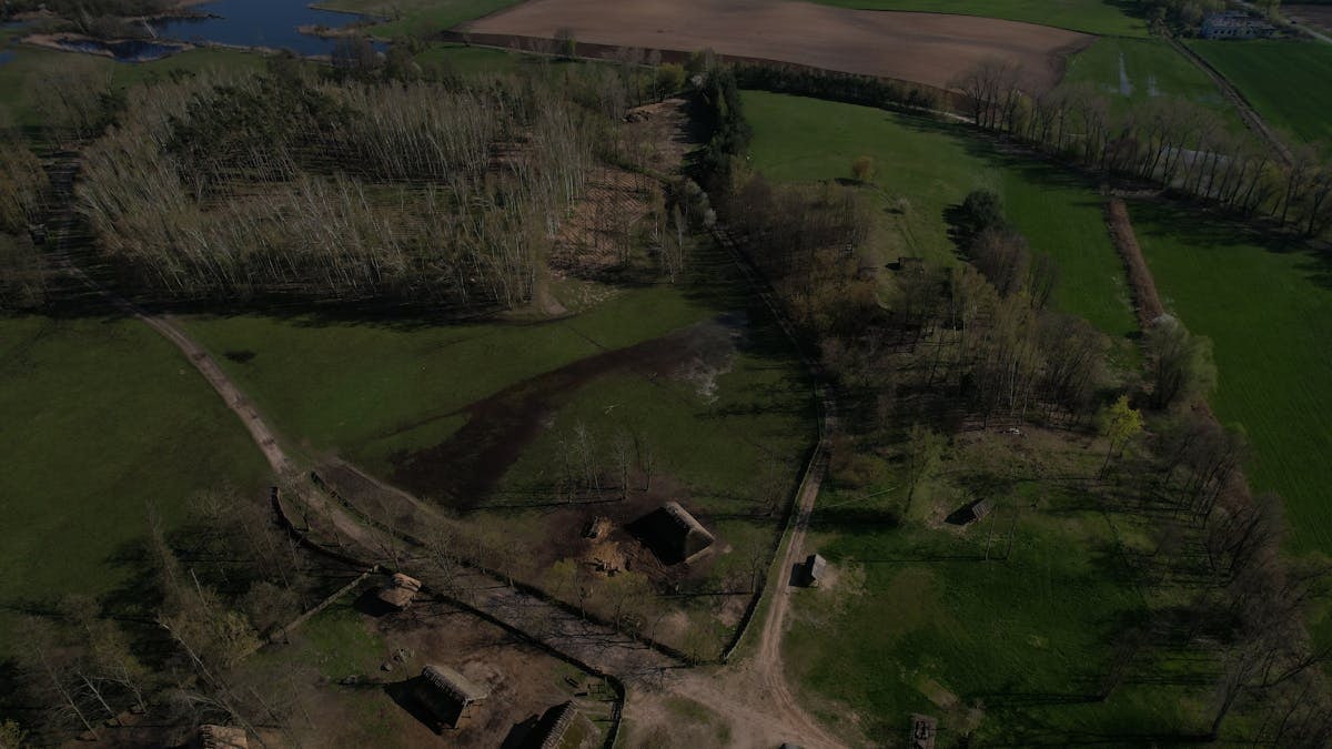 Aerial view showcasing the Biskupin archaeological site, highlighting its historic layout and rural landscape.
